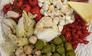 homemade antipasto platter with olives, tomatoes, cheese, and balsamic vinaigrette