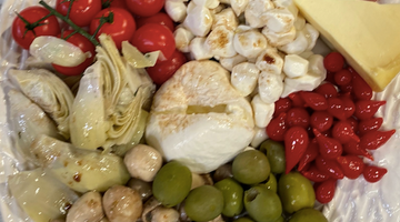 homemade antipasto platter with olives, tomatoes, cheese, and balsamic vinaigrette